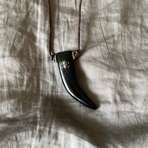 On leather , a black horn with silver skull on it